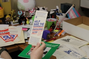 Photo of a hand holding a pamphlet that reads Help Save the Voting Rights Act.