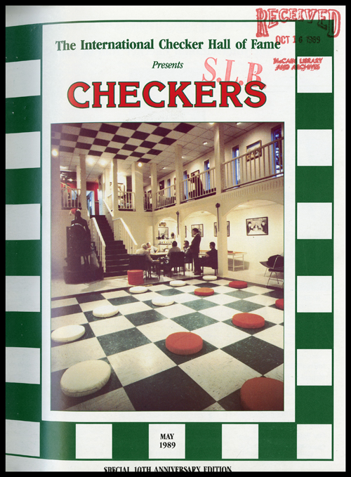 Cover of journal shows the words: International Checker Hall of Fame presents, and then the word: Checkers in large red script with green outline.  The photo below is of the inside of the Checkers Hall of Fame building where there is a large checkboard on the floor with giant checker pieces.  The ceiling is also checkered. In the background, are people sitting at a table presumably playing checkers.  The page is outlined in green and white checkers with May 1989 at the bottom of the page.