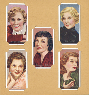 Five cigarette cards of famous film stars from the 1930s including Madge Evans, Heather Angel, Claudette Colbert, Una Merkel, and Katharine Hepburn. The cards are slotted into a page for an album housing cigarette cards.