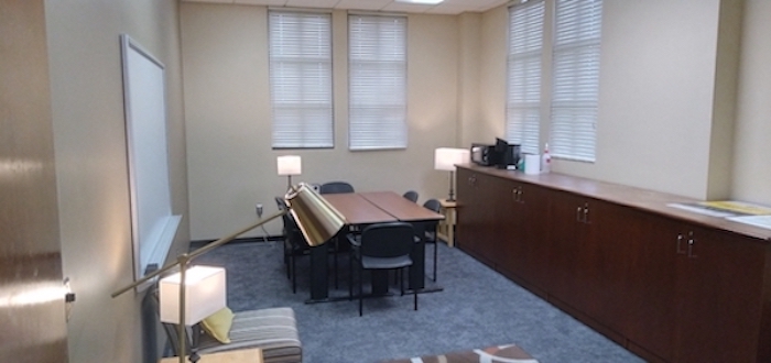 photo of room with conference table, long counter and white board