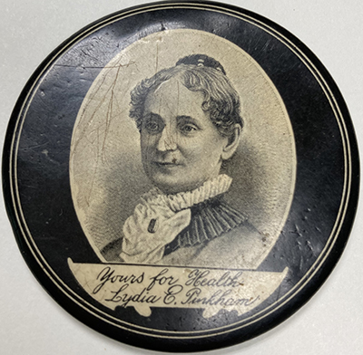 Front of circular pocket mirror with black and white portrait of Lydia E. Pinkham in 19th century dress inside a white oval shape on black background. A banner across the bottom of the portrait contains the handwritten script: Yours for Health. It is signed: Lydia E. Pinkham.