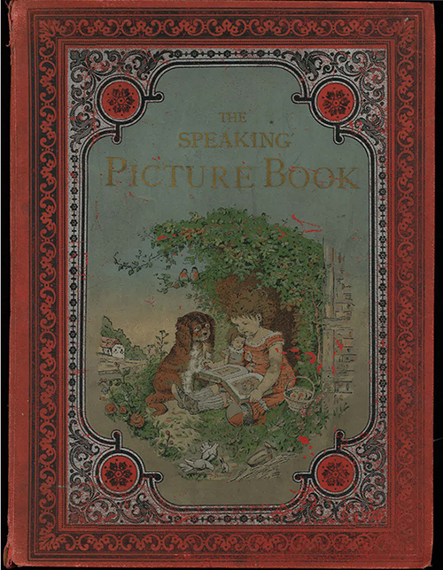 Image of the front cover of The Speaking Picture Book. The red cover is framed by a faded black border that uses leaf and floral elements, the pattern is repetitive and symmetrical. The inner border is white with the same black floral pattern. The corners are more lavish and have solid orange circles with 6-petal flowers. The center of the cover is of a young girl reading a book with her dog. They are sitting against the trunk of a tree with full, green leaves – a couple of robins sit in the branches. The green grass is a bit overgrown, with a rose garden nearby. A family of white doves peck at the ground in the foreground. The child is wearing an orange dress, grey knee-high socks, and simple black shoes. Her hair is brown and in a curly ponytail. In her lap, she is reading a picture book and holding a doll that looks like her. To her left is a ball and a wicker basket of cookies. To her right is her dog, which looks like a Cavalier King Charles Spaniel with a reddish-brown coat, a white chest, and white front legs. Above the image of the girl and her dog is the title, The Speaking Picture Book, in golden-yellow lettering. 